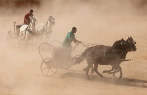 Re-enactment of a Roman chariot race with red and green tunic wearing rivals